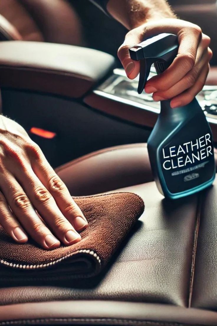 Person using leather cleaner spray with a cloth to clean the brown leather seat of a car.
